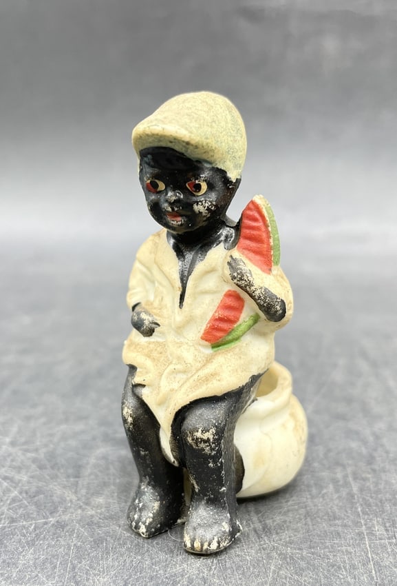 BLACK AMERICANA JAPAN BISQUE BLACK BOY ON CHAMBER POT W/ WATERMELON COIN IN BACK: DescriptionTitle: BLACK AMERICANA JAPAN BISQUE BLACK BOY ON CHAMBER POT W/ WATERMELON COIN IN BACKDate/Period: APPROX 1930-40'SDimension: Approx 3"Material: bisqueAdditional Information: BLACK AMERICA