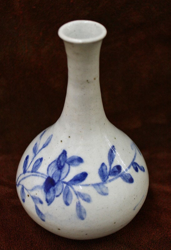 19th Century Blue and White Porcelain Peony Bottle: 19th Century Korean Blue and White Porcelain Bottle with Beautifully Painted Peony Sprays. The peony is an ancient symbol of love and prosperity in Korea. 7.5h x 4.5w inches, 19h x 11.5w cm. Reserve: 