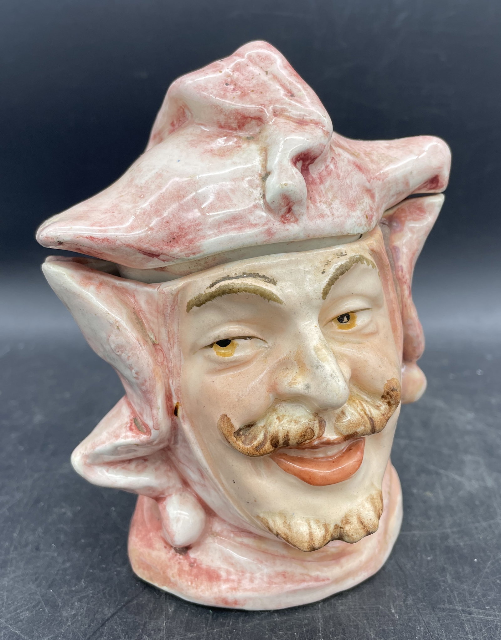 VINTAGE FIGURAL TOBACCO JAR COURT JESTER MAJOLICA: Title: VINTAGE FIGURAL TOBACCO JAR COURT JESTER MAJOLICA Date/Period: UNKNOWN Dimension: APPROX 5.5 X 3.75 X 3.5 Material: CERAMIC Additional Information: VINTAGE FIGURAL TOBACCO JAR COURT JESTER MAJO