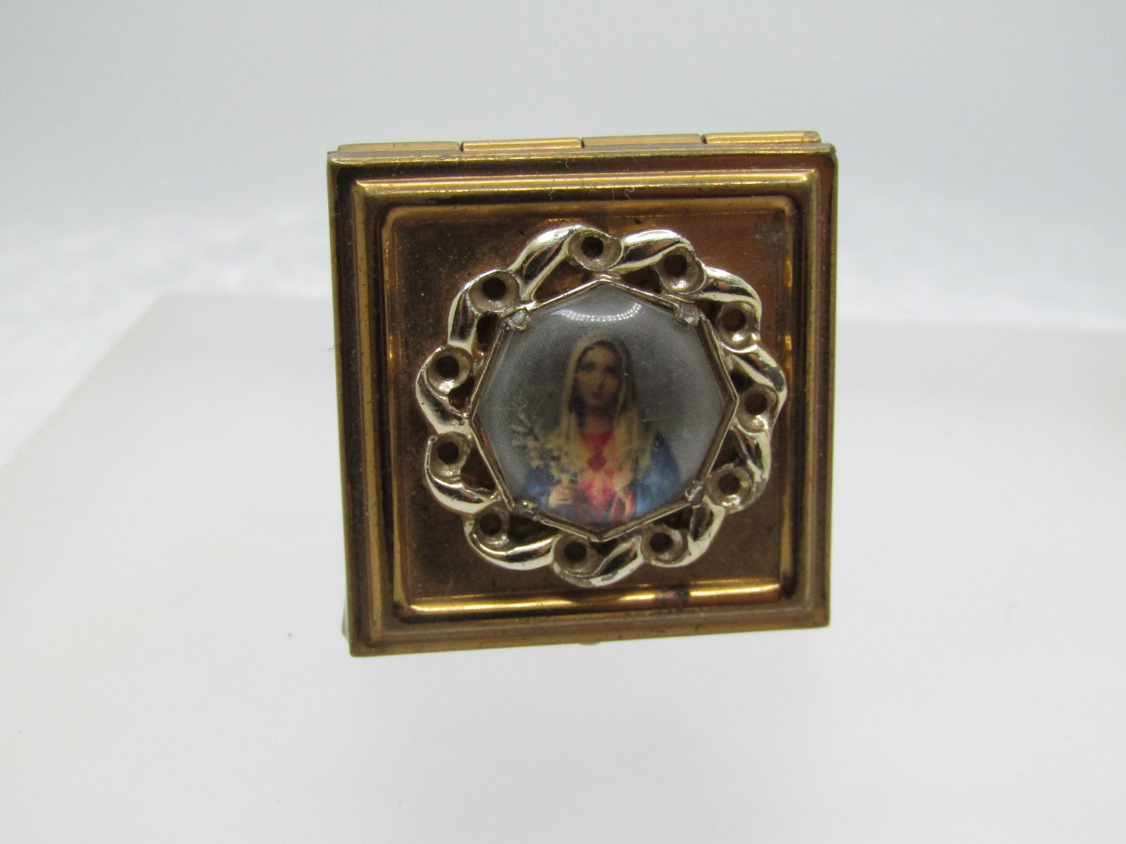 Vintage Blessed Mother Pill Box, 1950's-1960's, 1.25" Square: Vintage Blessed Mother Pill Box, 1950's-1960's, 1.25" Square. Hinged Lid with a brassy metal box and a silver tone frame around an eight-sided framed Blessed Mother. Not signed or marked. Good to very