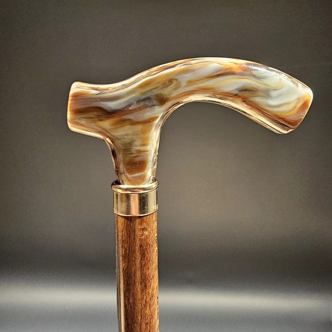 Marbleized Acrylic Wood Walking Cane: This reproduction Spanish cane features a brown marbleized acrylic handle mounted stylishly on a hardwood shaft with a walnut stain finish. Imported from Spain. It's attached to a sturdy 3/4" wood sha