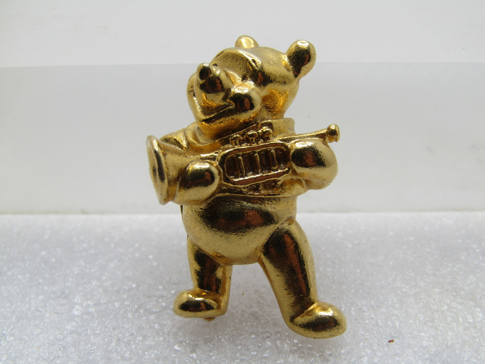 Vintage Winnie the Pooh, Brooch with Trump, Signed Disney, 1980's: Vintage Winnie the Pooh, Brooch with Trump, Signed Disney, 1980's. Gold tone with locking clasp. Signed Disney with copyright mark. Winnie is holding a trump. The brooch is appx. 1.5" tall and 1" wide