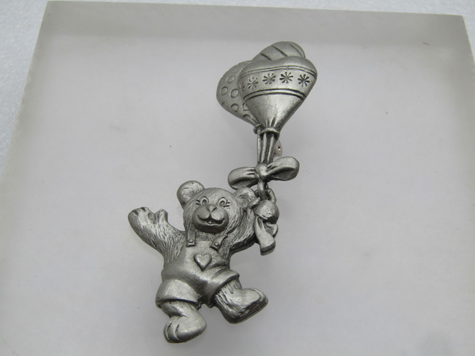 Vintage Pewter Teddy Bear & Balloons Brooch, Signed SP 4202, 1980's-1990's.: Vintage Pewter Teddy Bear & Balloons Brooch, Signed SP 4202, 1980's-1990's. This has a teddy bear wearing overalls with a heart holding on to a bunch of balloons (three). He is attached at the bow bel