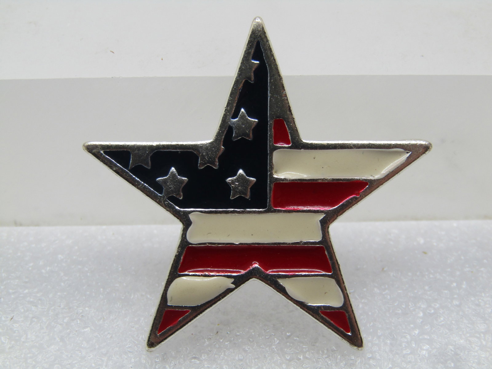 Vintage Enameled USA Flag/Star Brooch, 1980's-1990's: Vintage Enameled USA Flag/Star Brooch, 1980's-1990's. Silver tone and appx. 1,75" from point-to-point. With stripes and star field enameled in a recessed design that when enameled is even with the fra