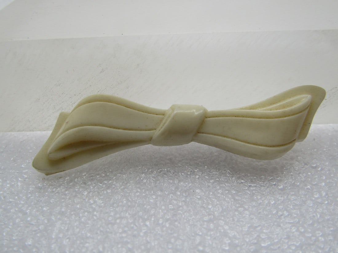 Vintage White Plastic Bow Brooch, Western Germany, 1940's-1950's: Vintage White Plastic Bow Brooch, Western Germany, late 1940's-1950's. This is a white plastic thin bow that is appx. 1/2" at the widest point and 1/3" at the center. 2.25" long. Marked Western German