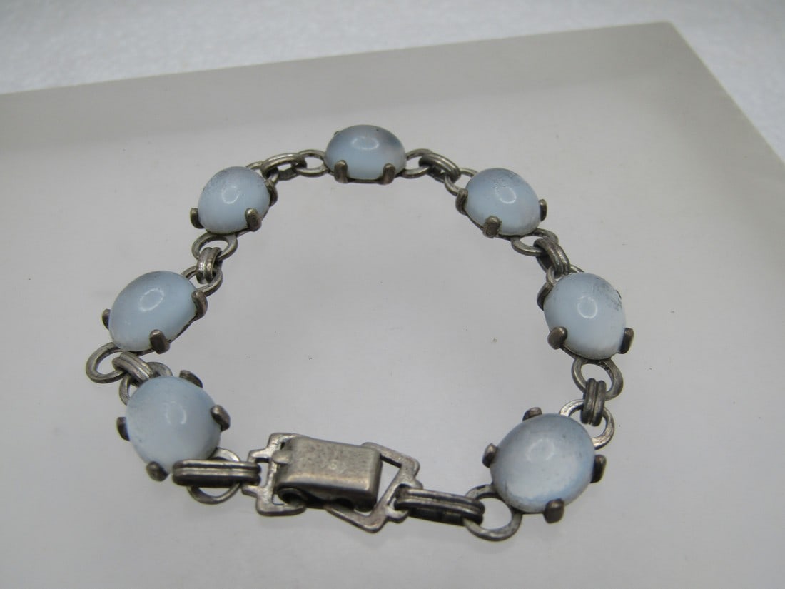 Vintage Sterling Blue Glass Moonstone Bracelet, Signed Wre, 1950's-1960's, 6.5": Vintage Sterling Blue Glass Moonstone Bracelet, Signed Wre, 1950's-1960's, 6.5". Oval 9mm by 7.5mm blue moonstones that are glass. Flip clasp where it is marked sterling and signed by the maker, WRE (