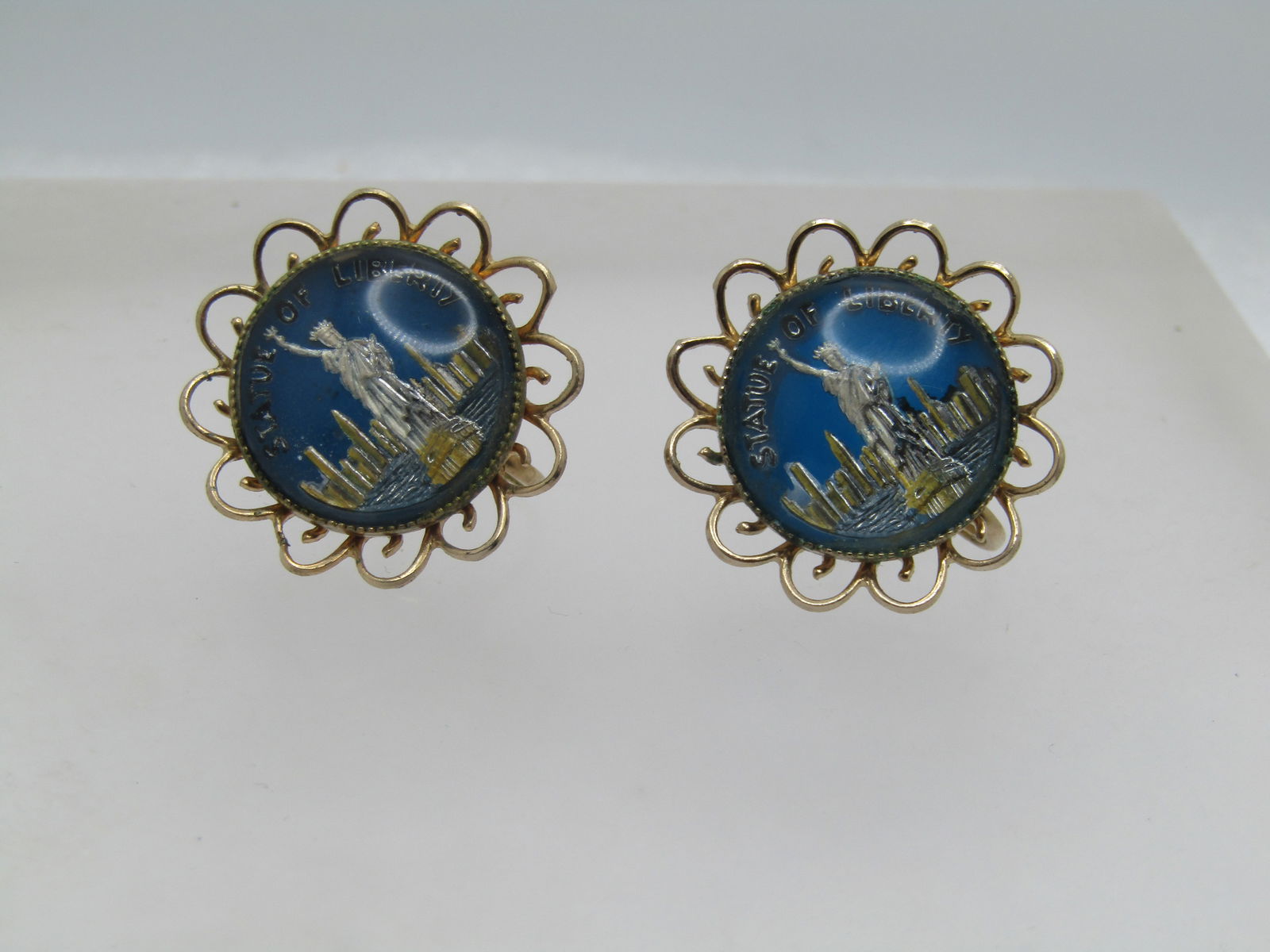 Vintage Coro Statue of Libery Earrings, Screwback, 1950's-1960's: Vintage Coro Statue of Libery Earrings, Screwback, 1950's-1960's. Blue background with Silver Tone Statue of Libery, Skyline, and State of Liberty wordding. domed glss covering - gold tone open scallo