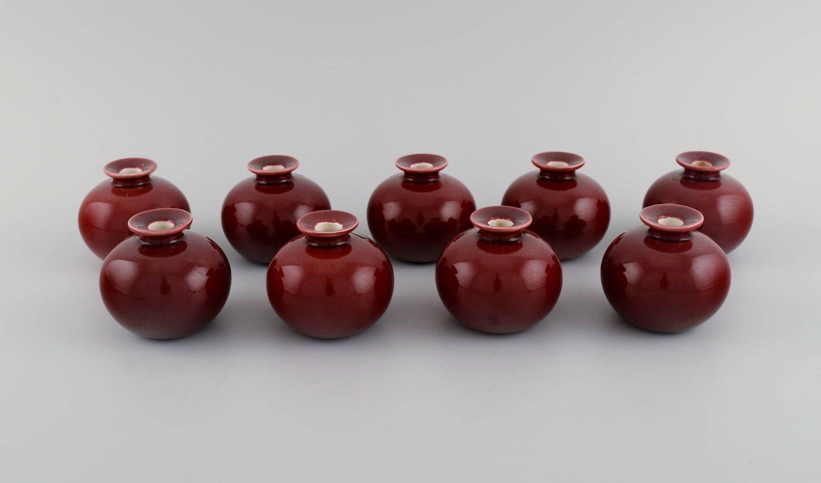 9 round Rörstrand candlesticks in glazed faience. Beautiful glaze in burgundy red shades. (1 of 5)