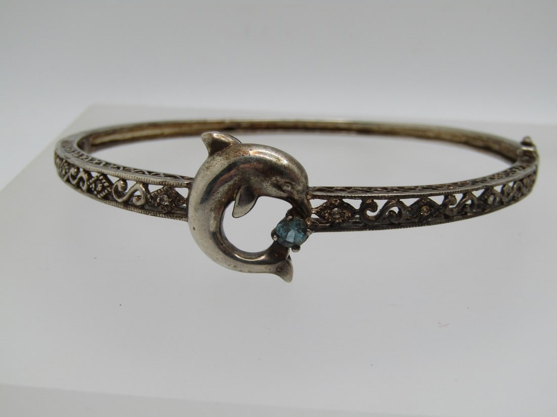 Vintage Sterling Blue Topaz Dolphin Hinged Bangle Bracelet, 7.5", Signed CC: Vintage Sterling Blue Topaz Dolphin Hinged Bangle Bracelet, 7.5", Signed CC. Marked .925 and tested with a weight of appx. 12.08 gr. 4mm round blue topaz. This has a filigree scrolled design on top ha