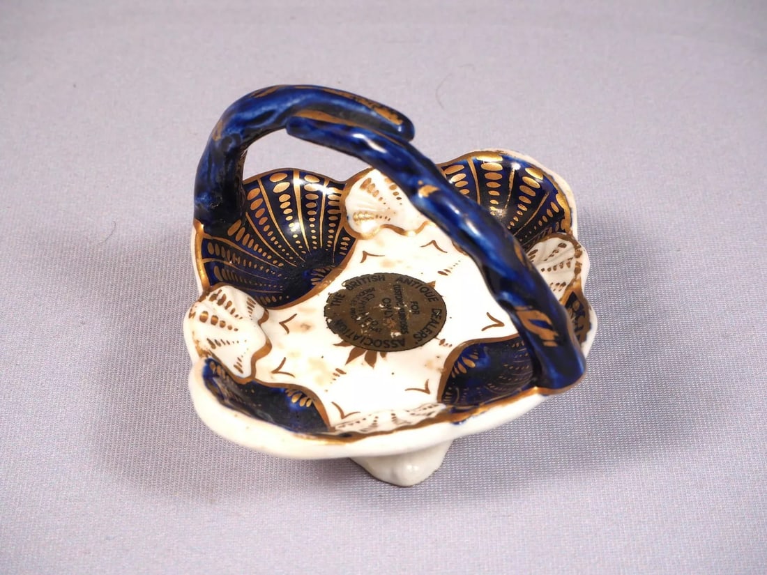Antique Porcelain Cobalt Basket Tray Candy Nut Dish Handles Certified 1847: This is an exceptional small Basket/Nut Dish/Tray.. It is in cobalt blue and gold. It bears and British antique Dealers Association certifying that is made prior to 1827. It is aprox. 3 1/4" by 3" at
