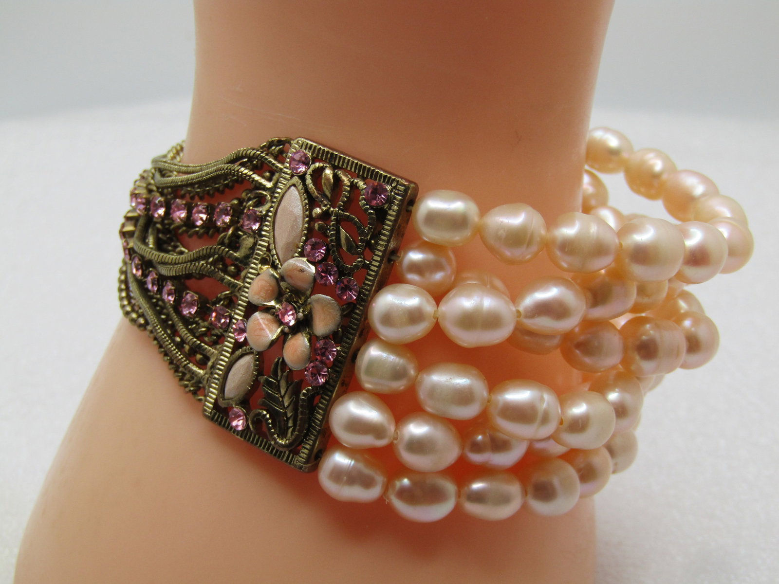 Baroque Pearl Multi-Strand Bracelet with 12 Strands, Mixed Chains, Enameled Flowers 7": Baroque Pearl Multi-Strand Bracelet with 12 Strands, Mixed Chains, Enameled Flowers 7". Age is appx. 1990's. This has six strands of a pale tan or blush faux or cultured baroque pearls in six strands.