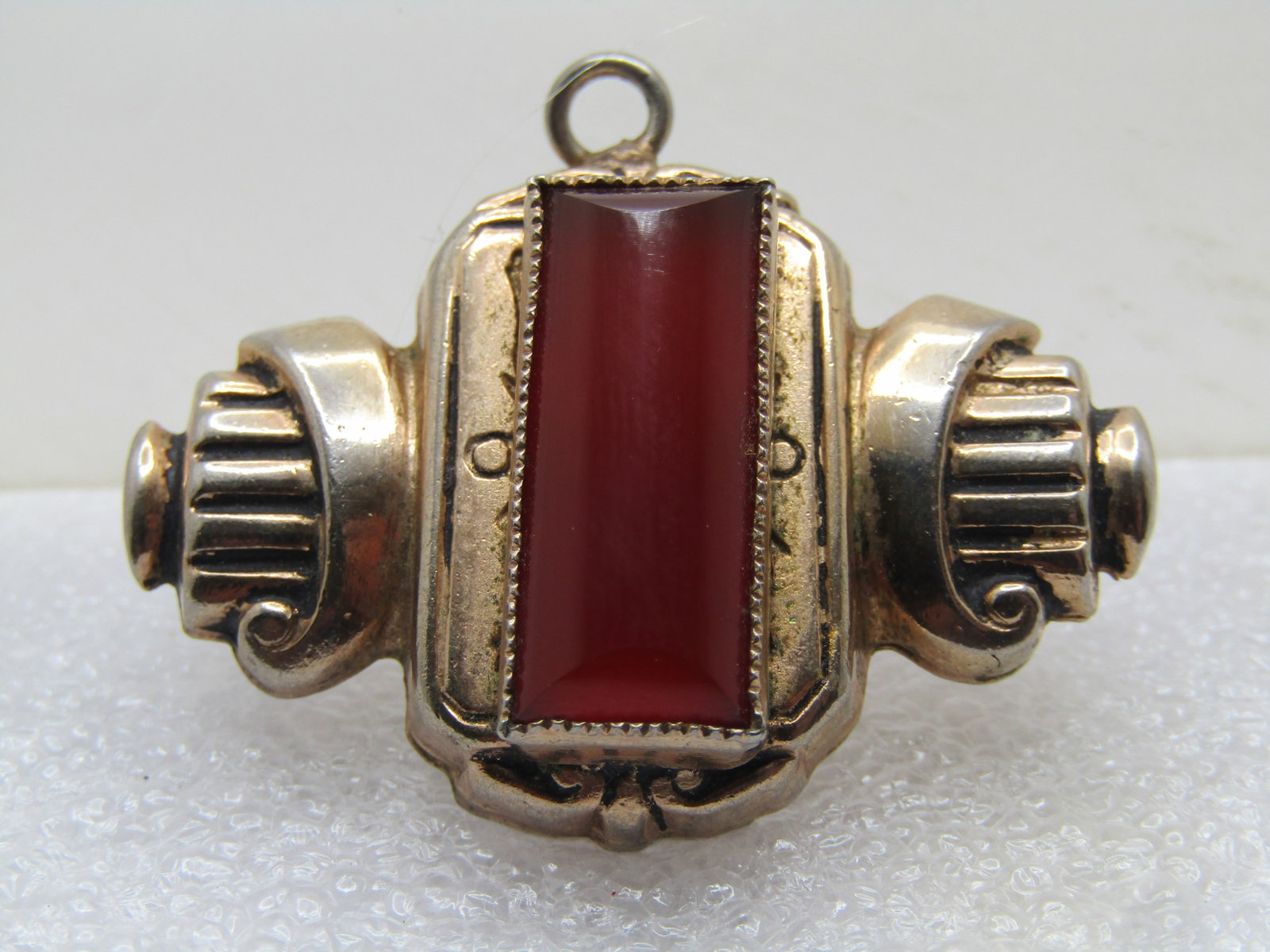 Vintage 10kt G.F. Carnelian Brooch/Pendant, 1930's: Vintage 10kt G.F. Carnelian Brooch/Pendant, 1930's . It has the loock of a scroll one ch side of the sawtooth bezel-set carnelian stone that is set on a base that has stamped markings near the stone. 
