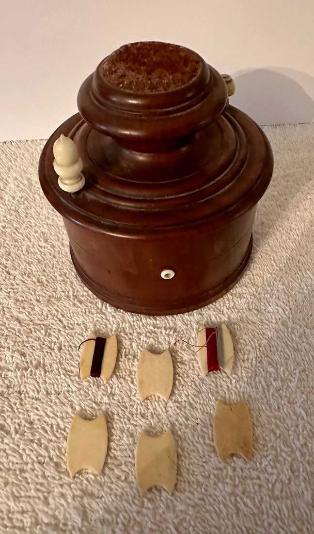 Round Wooden Sewing Caddy/Box w/Bobbins: A round, wooden sewing caddy or box with a swivel lid, pin cushion on top and bone eyelets, probably from the late 19th century or very early 20th century. The box is 4” in diameter and just abo