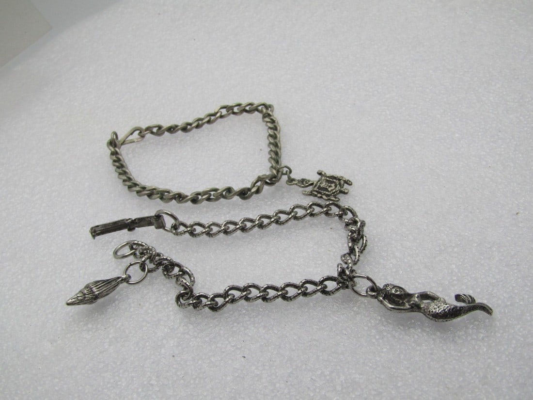 2 Vintage Charm Bracelets, Sea & Coat-of-Arms, 1950's-1960's: 2 Vintage Charm Bracelets, Sea & Coat-of-Arms, 1950's-1960's. One has a single coat-of-arms charm and is a 4mm wide curb link with a swivel type of cuff link clasp. It is 7" and does test as sterling