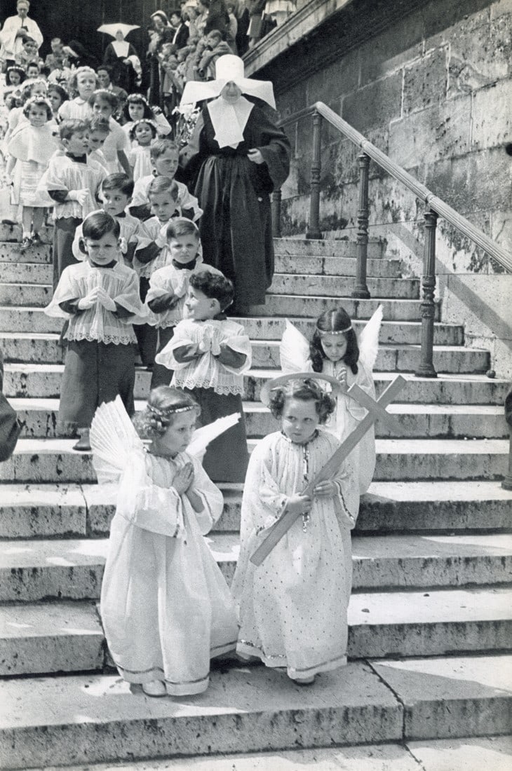 HENRI CARTIER-BRESSON - Corpus Christi Procession: Artist: Henri Cartier-Bresson Title: Corpus Christi Procession At The Church Of The Madeleine, Paris Medium/Date: Sheet Fed Gravure, 1955, France Dimensions: 8.95x13.5" Descripition: Heat Wax Mounted