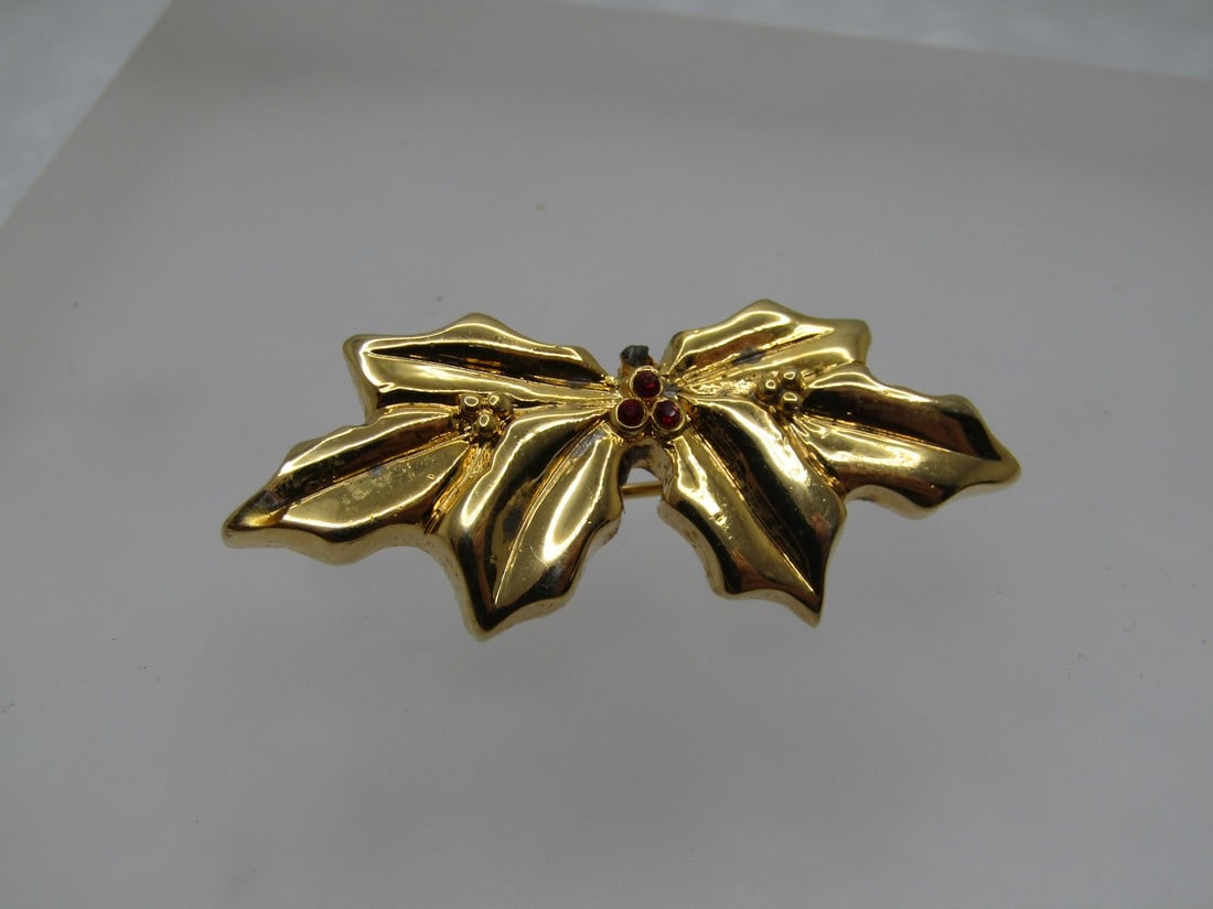 Vintage Christmas Holly Brooch, Red Berries, 1970's-1980's: Vintage Christmas Holly Brooch, Red Berries, 1970's-1980's. Gold tone and appx. 1.75" wide and .75" tall. Three small red berries in the center. The pin is bright and shiny. There may have been a piec