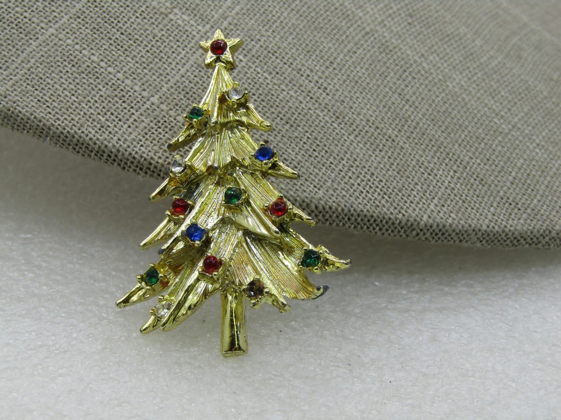 Vintage Rhinestone Christmas Treet Brooch, 2": Vintage Rhinestone Christmas Tree Brooch, 2" by 1=3/8", gold tone with mixed colore rhinestone ornaments and a red star on top. Textured finish. 1960's-1970's. Not signed by the maker. Very good condi