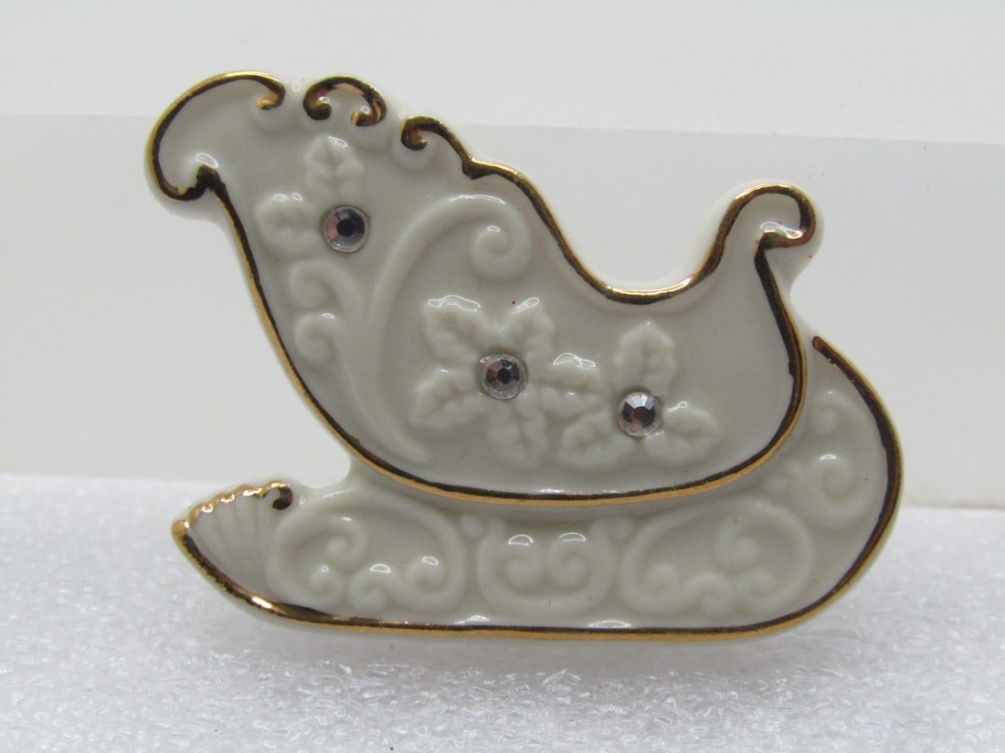 Vintage Lenox Christmas Sleigh Brooch, Gold Trim/Rhinestones, 1980's: Vintage Lenox Christmas Sleigh Brooch, Gold Trim/Rhinestones, 1980's. It is appx. 1.5" wide and 1.25" tall at the highest point Very clean and in very good condition. (W8415.3 SS14382 AZ J LD 8/18/24)