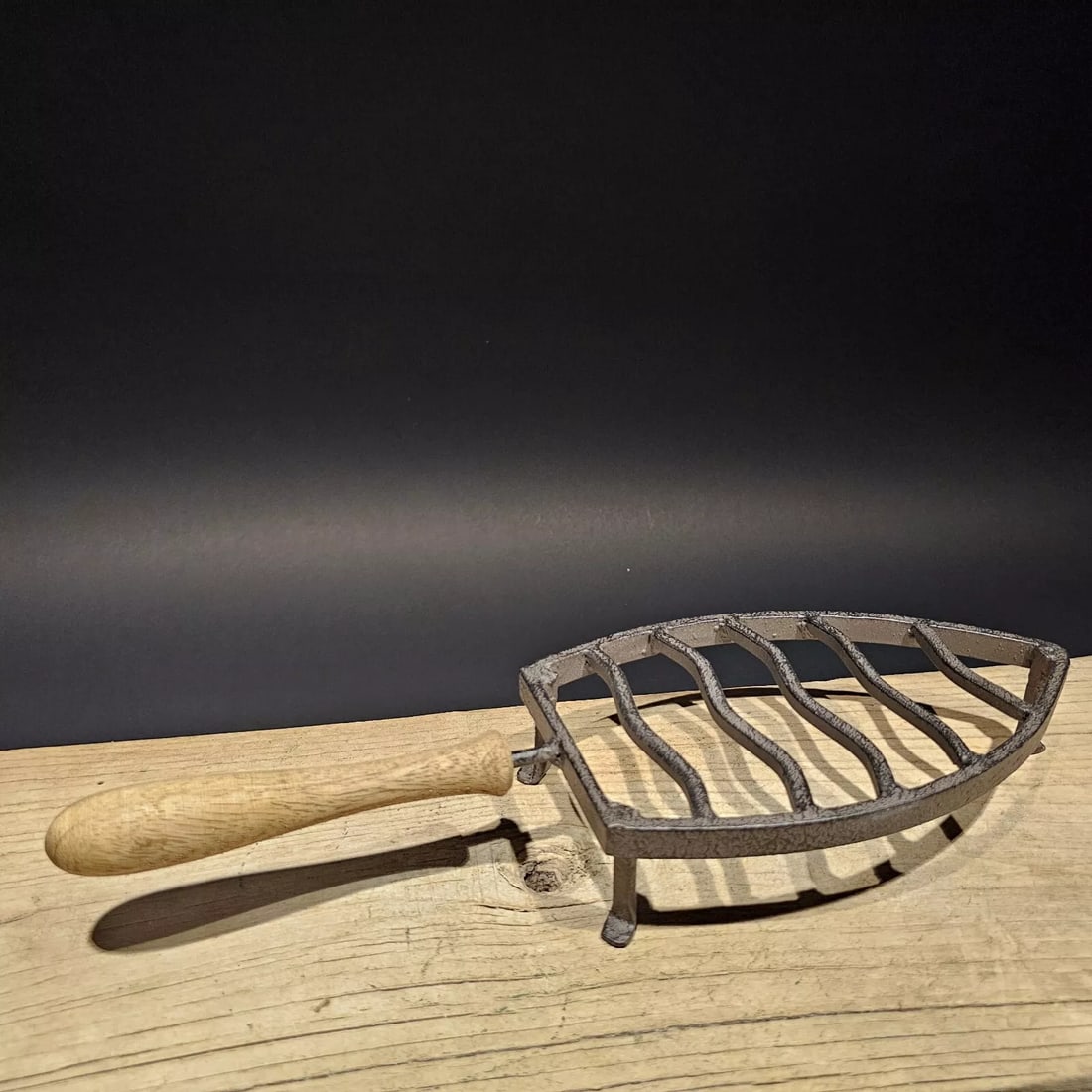 Primitive Cast Iron Trivet: 13 3/4" Long x 4 3/4" Wide Wonderful reproduction cast iron trivet with a wood handle. Great piece! Distressed to look old but is new. All our items come with a 100% customer satisfaction guarantee. A