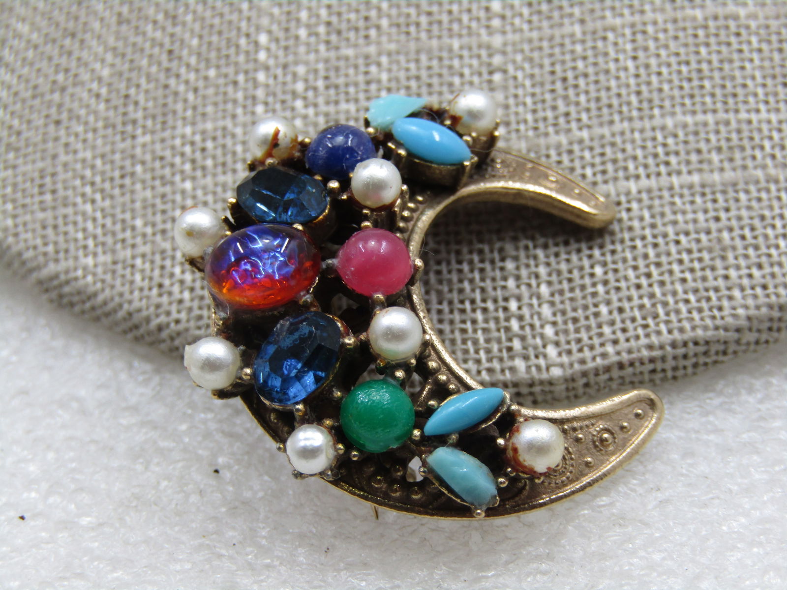 Vintage Coro Rhinestone Crescent Brooch, 1940's: Vintage Coro Rhinestone Crescent Brooch, 1940's. Celestial, 1.25" tall and wide with a mix of faux pearls faux turquoise, opal, sapphire blue, jade green, and pink stones. Stones are a mix of shapes.