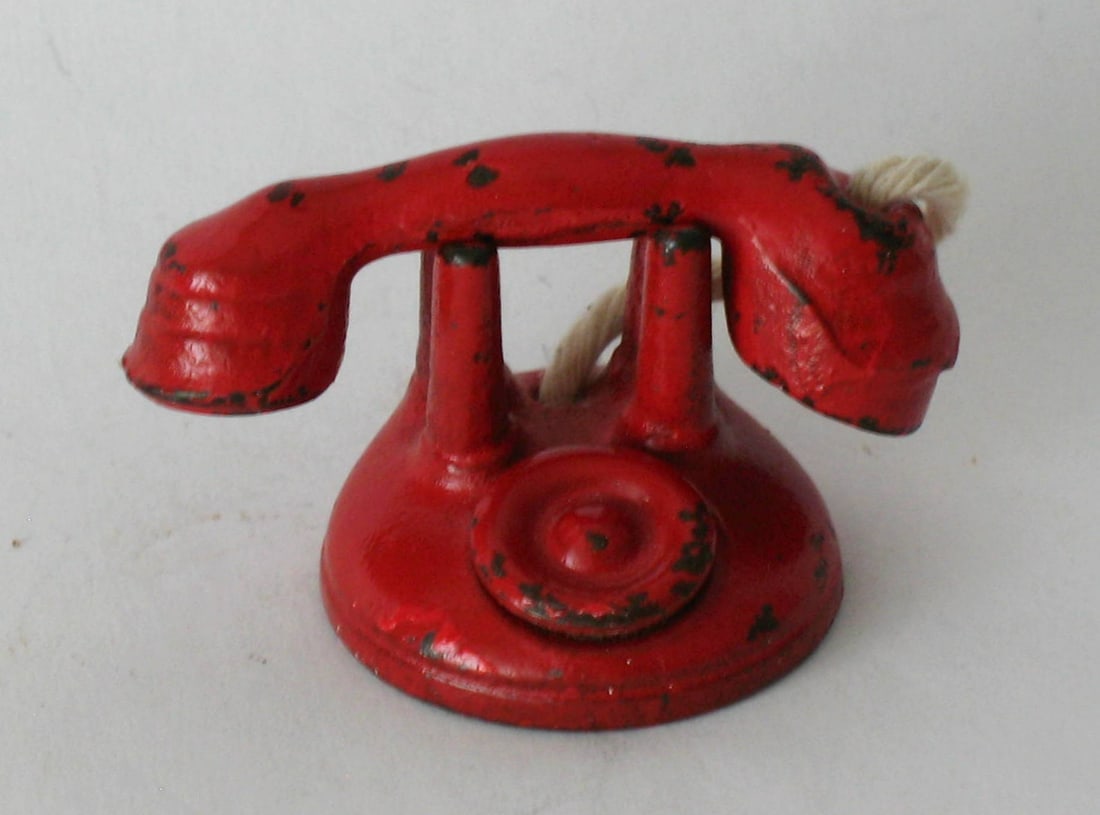 Antique cast iron red telephone paper weight.: Title: Antique cast iron red telephone paper weight. Date/Period: 1930's Dimension: 2 1/4” Additional Information: Nice antique cast iron telephone paper weight in whimsical red paint. Shipping: