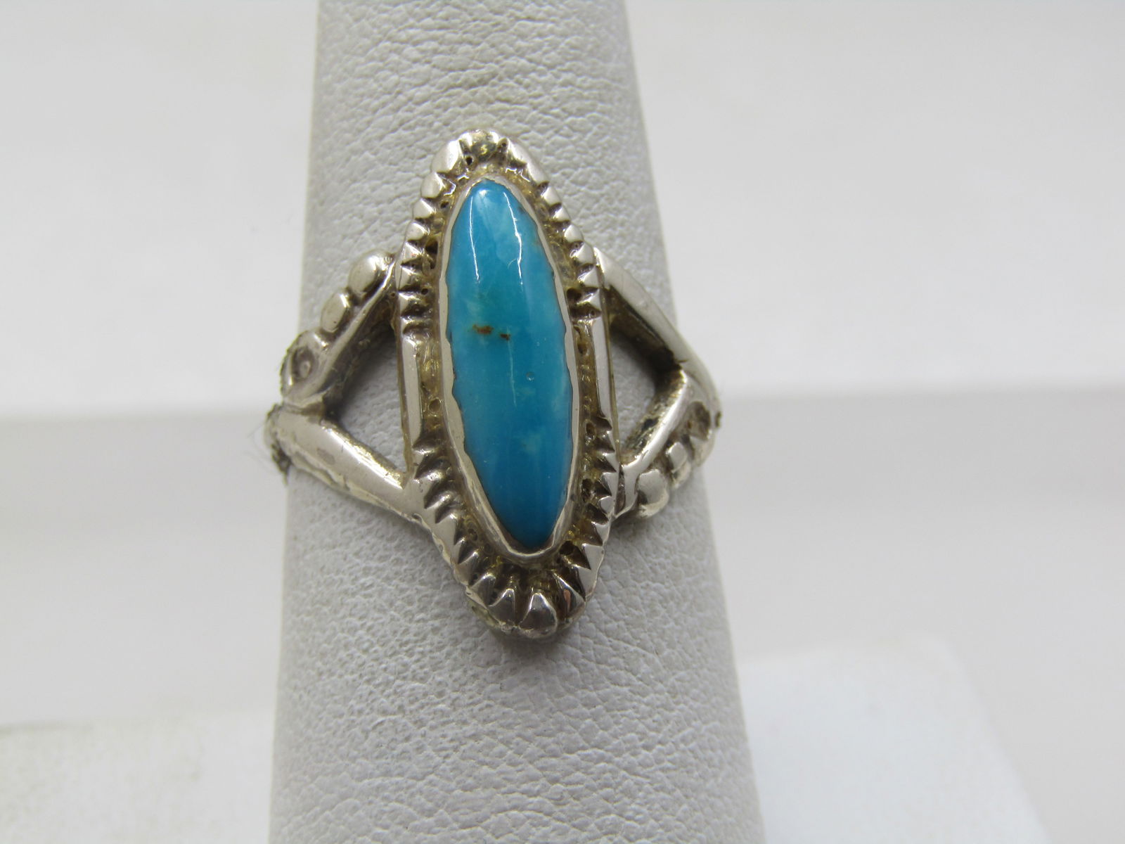 Vintage Sterling Southwestern Turquoise Ring, Sz. 8: Vintage Sterling Southwestern Turquoise Ring, Sz. 8. This has a long turquoise stone that is appx. 15mm by 4.5mm, bezel-set with a wider base and stamped accents on the base and beaded accents on the