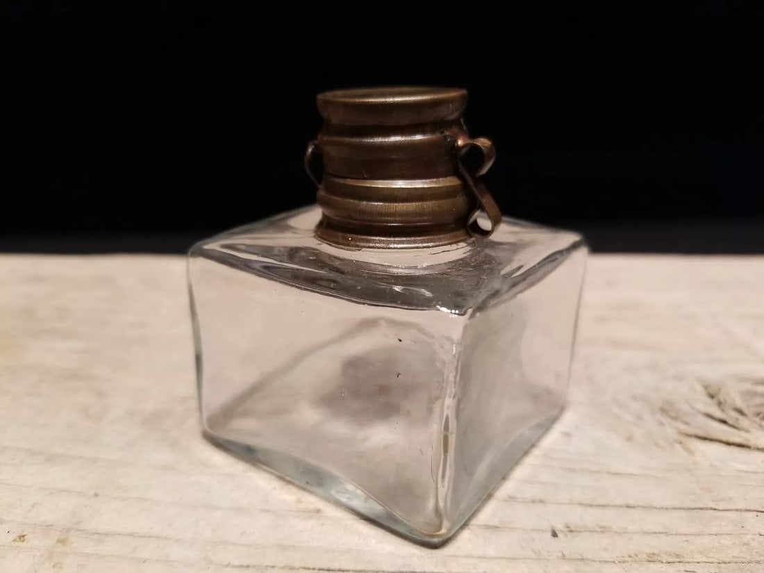 Square Glass Inkwell Ink pot Bottle: Charming 2 3/8" High x 2"x 2" square Reproduction antique clear glass inkwell. Nice reproduction thin glass inkwell. Each with charming subtle signs of being hand made. The hinged lid is antiqued bras