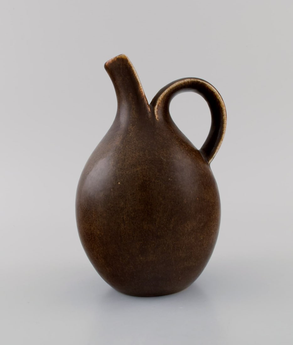 Eva Stæhr-Nielsen for Saxbo. Pitcher in glazed stoneware. Beautiful glaze in brown shades.: Eva Stæhr-Nielsen for Saxbo. Pitcher in glazed stoneware. Beautiful glaze in brown shades. Model number 64. Mid 20th century. Measures: 19 x 13 cm. Stamped. In excellent condition. Reserve: $1,40