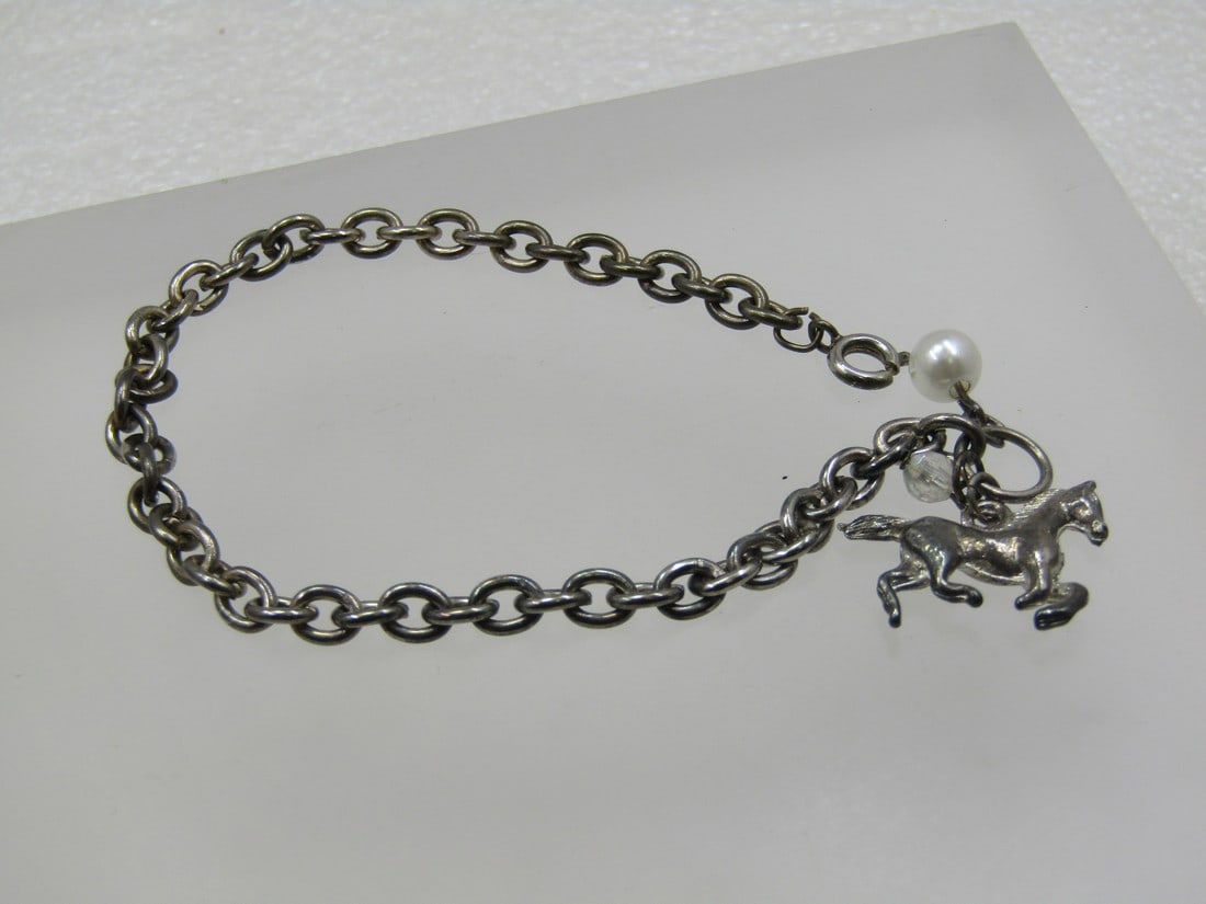Vintage Silver Tone Horse Charm Bracelet, 7.5": Vintage Silver Tone Horse Charm Bracelet, 7.5" with a faux 5.5mm white pearl and a clear 3mm crystal bead. The link is an oval aternating direction link that is appx. 4.5mm. 1960's. Good condition wit