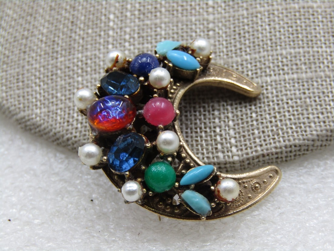 Vintage Coro Rhinestone Crescent Brooch, 1940's: Vintage Coro Rhinestone Crescent Brooch, 1940's. Celestial, 1.25" tall and wide with a mix of faux pearls faux turquoise, opal, sapphire blue, jade green, and pink stones. Stones are a mix of shapes.
