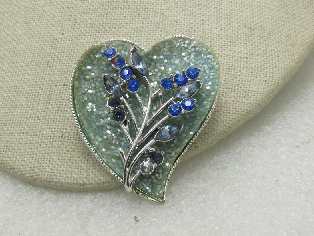 Vintage Coro Glitter & Rhinestone Heart Brooch, Mid-Century, 2": Vintage Coro Glitter & Rhinestone Heart Brooch, Mid-Century, 2" tall and 1.5" wide. Offset heart design with a background of seafoam heavy glitter - and a floral stem over top with marquise and round