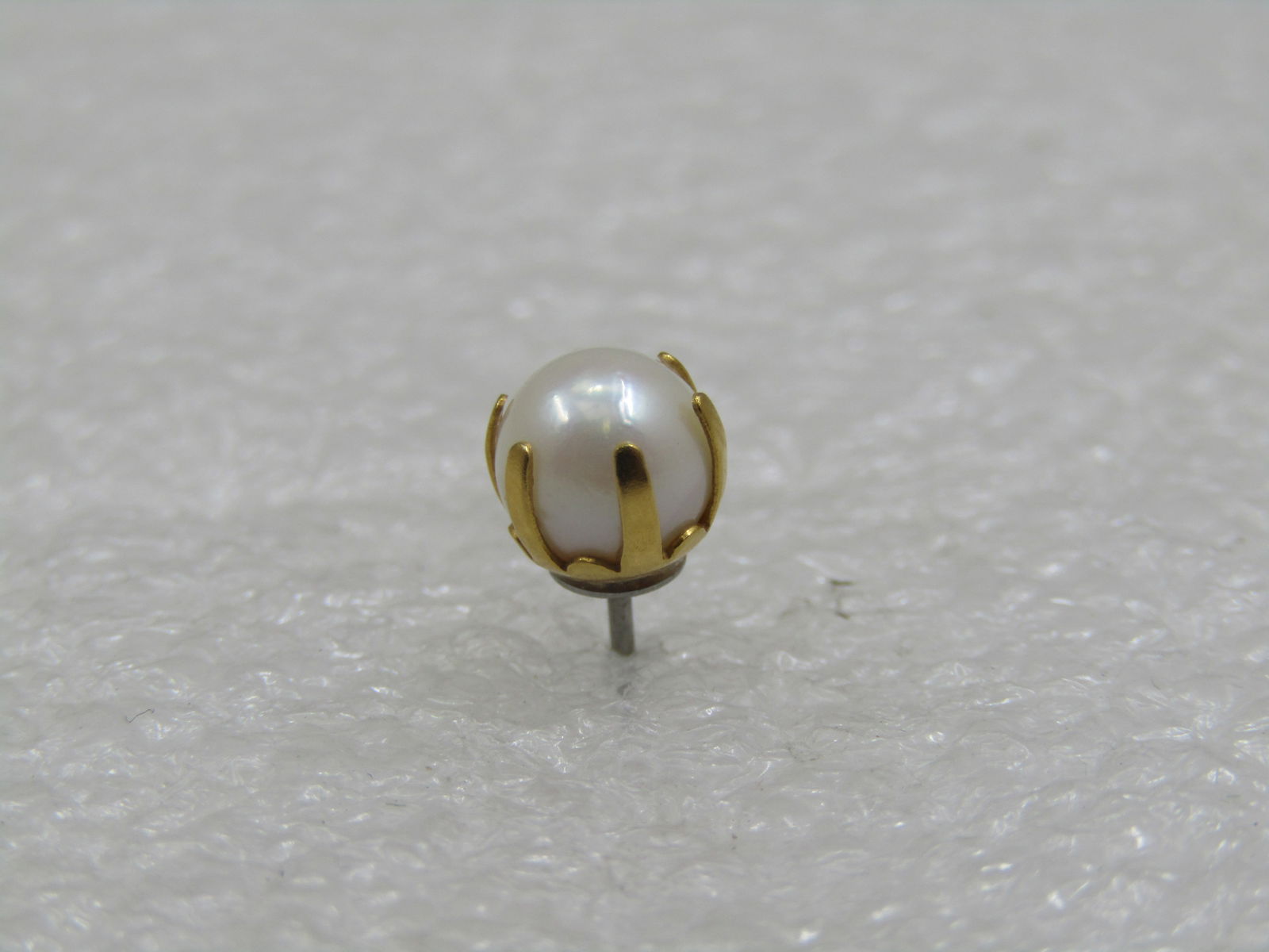Vintage 14kt Single 6mm Pearl Stud Earring, Pierced: Vintage 14kt Single 6mm Pearl Stud Earring, Pierced. It is not signed or marked but has been tested. The cage around the pearl has 6 prongs. it is yellow gold with appx. .62 gr weight. It has a white