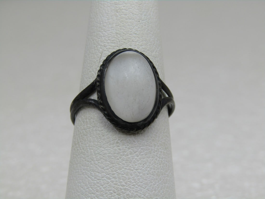 Vintage Sterling White Cateye Moonstone ring, Sz. 7: Vintage Sterling White Cateye Moonstone Ring, Sz. 7. It has a white opaque moonstone with cateye opalescence. Bezel-set cabochon with rope accident. The stone is appx. 14mm by 10mm oval. The band is a
