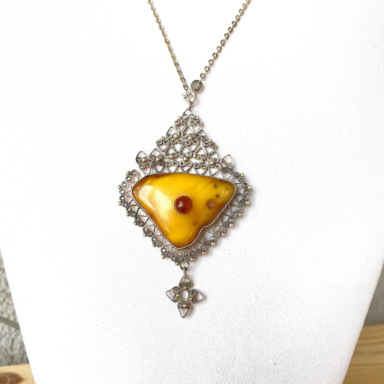 Beautiful Vintage Amber Pendant shaped like an Ornament: Title: Beautiful Vintage Amber Pendant shaped like an Ornament Metal: Metal Gemstone: Amber Weight: 10.5 g Size: Size: 75.0 x 50.0 x 10.5 mm Size: 2.953 x 1.969 x 0.413 inches Made of: (Reconstituted 
