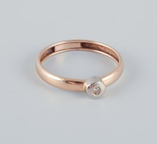14 karat gold ring with a small diamond in a modernist design.