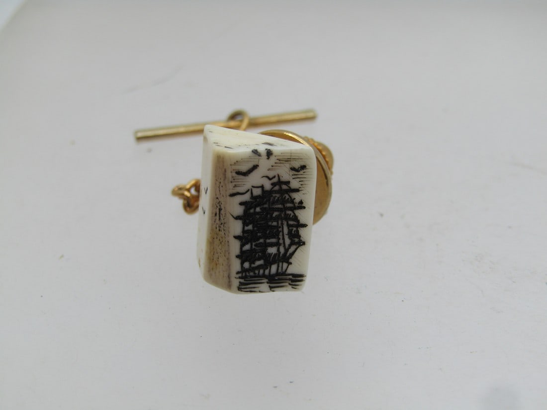 Vintage Tall Ship Scrimshaw Tack Pin 1960's-1970's.: Vintage Tall Ship Scrimshaw Tack Pin 1960's-1970's, gold tone clutch and bar with chain. The tack pin is appx 1/2" tall and wide, angled on the side, with a center ridge. The right side has the tall s