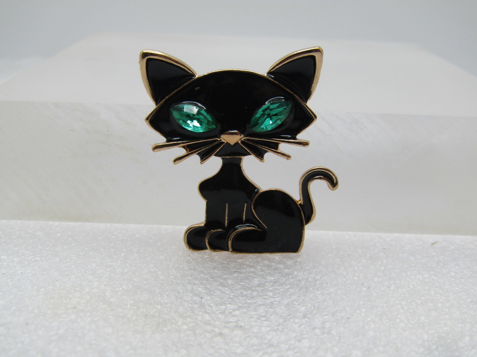 Black Enameled Cat Brooch, Green Marquise Glass Eyes, 2000's: Black Enameled Cat Brooch, Green Marquise Glass Eyes, 2000's. Gold tone with thick black enameled and gold tone framing and nose and whiskers and large green marquise glass rhinestone eyes that are ap