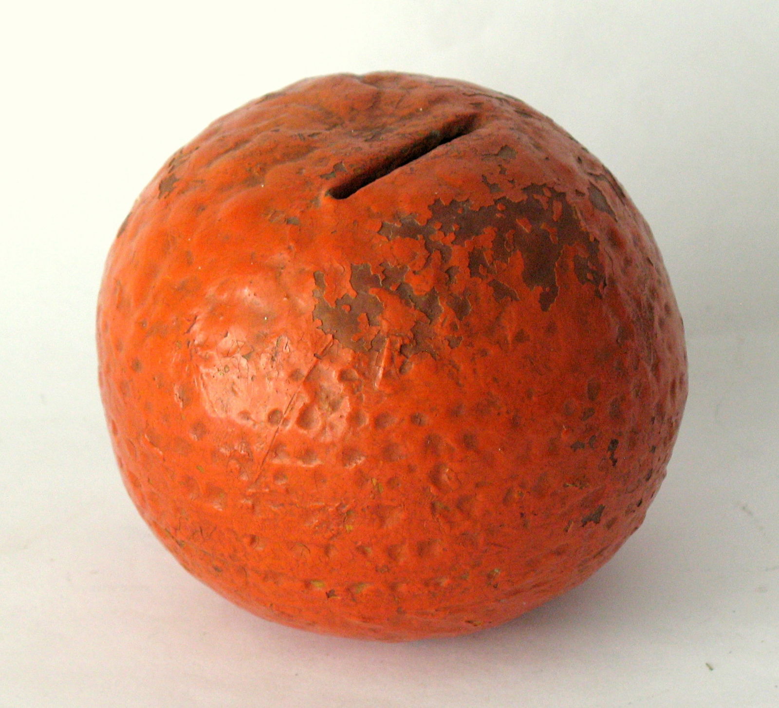 Antique red ware bank in the shape of an orange.