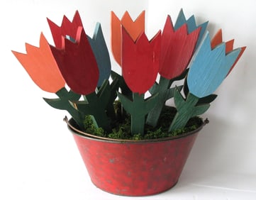 Group of vintage folk art wood tulips in red tin bucket.