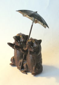 Antique cast metal bears under umbrella paper weight.