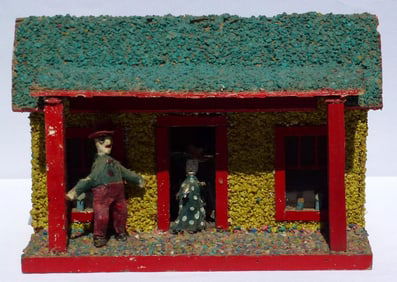Folky model cabin with a carved man and woman