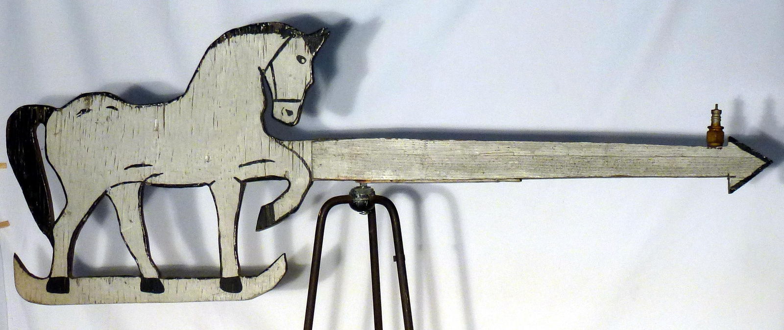 A wooden horse weather vane in weathered gray and black paint: A nice wooden horse weather vane in weathered gray and black paint on both sides. An old spark plug was added to the front of the arrow to make it balance. It is 44 1/2" long by 16" high. The horse is