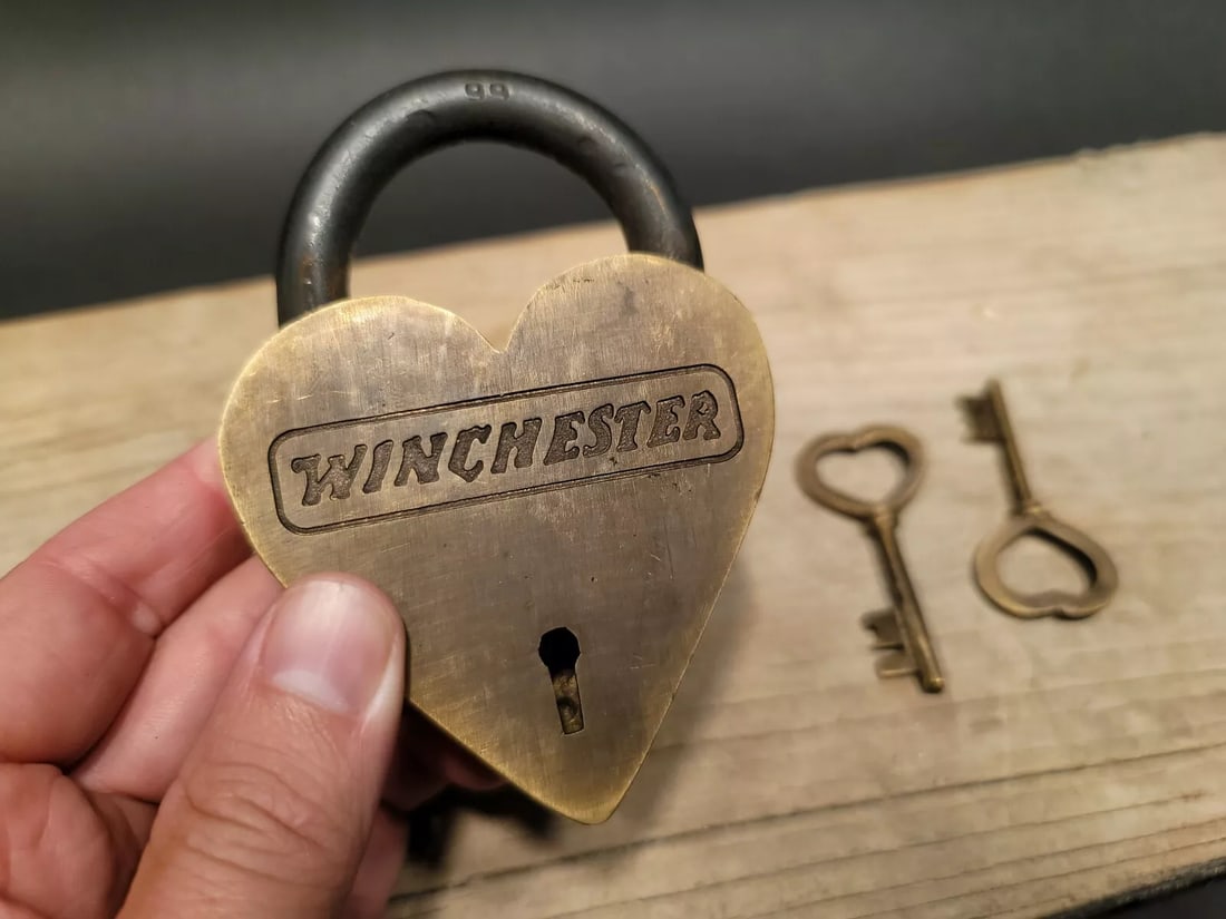 Brass Heart Winchester Firearms Ammo Box Padlock Lock: 3" tall x 4 1/4" Wide Nice reproduction brass winchester padlock! This lock is fully functional! Hard to tell its age. Heavy iron and brass. Great aged patina throughout. Limited quantity available! R