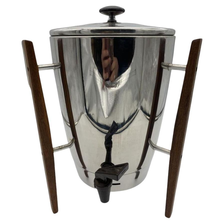 Mid Century Chrome and Teak Coffee Maker by Regal: The "Mid-Century chrome coffee maker with teak legs by Regal" is a stylish and functional coffee maker designed with elements typical of mid-20th-century modern aesthetics. This coffee maker features