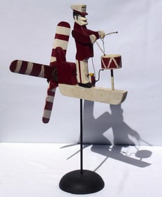 A colorful whirligig of a uniformed drummer