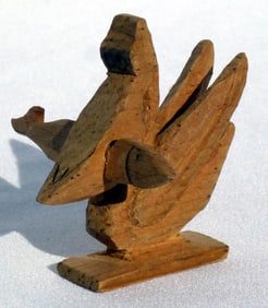 A whimsy carving of a pelican with a fish