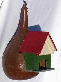 A painted birdhouse of wood into a gourd