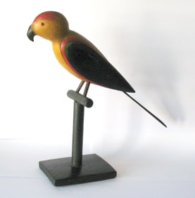 Vintage colorful folk art wood carved parrot on it's perch.
