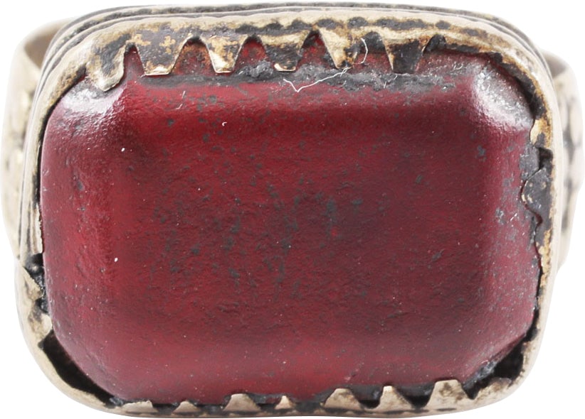 EASTERN EUROPEAN GYPSY RING, 19TH CENTURY, SIZE 8 ½: 19th century. White metal band 4.3mm width flaring to the foliate and pellet decorated shoulders. Large rectangular bezel with cabled bottom and saw tooth edge (small loss) and faceted red “ston