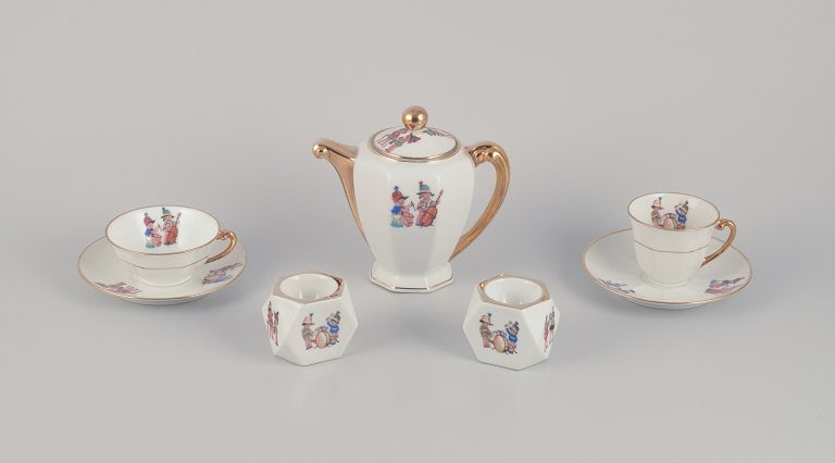 Limoges Porcelaine, France. Coffee pot, teacup, and a coffee cup with saucers, as well as two egg: Limoges Porcelaine, France. Coffee pot, teacup, and a coffee cup with saucers, as well as two egg cups in porcelain. Motifs of child musicians. 1930s/1940s. In excellent condition with minimal signs o